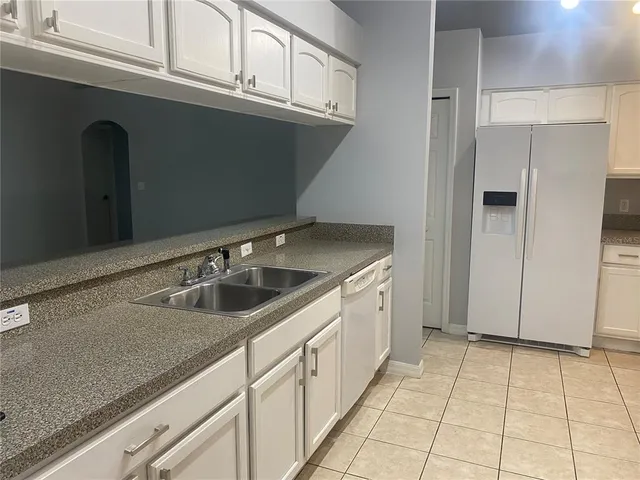 a kitchen with stainless steel appliances granite countertop a sink and a refrigerator