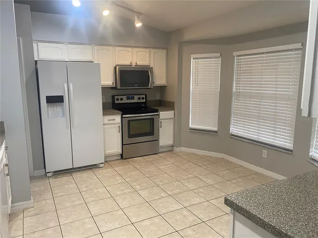 a kitchen with stainless steel appliances granite countertop a refrigerator and a stove