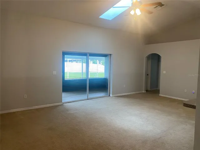 an empty room with chandelier fan