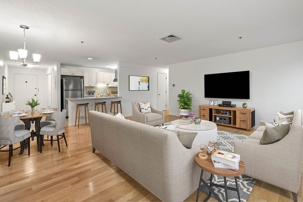 36 Dunham Road, Unit 306 Beverly, MA 01915 - Photo 1 of 26 a living room with furniture a dining table and a flat screen tv