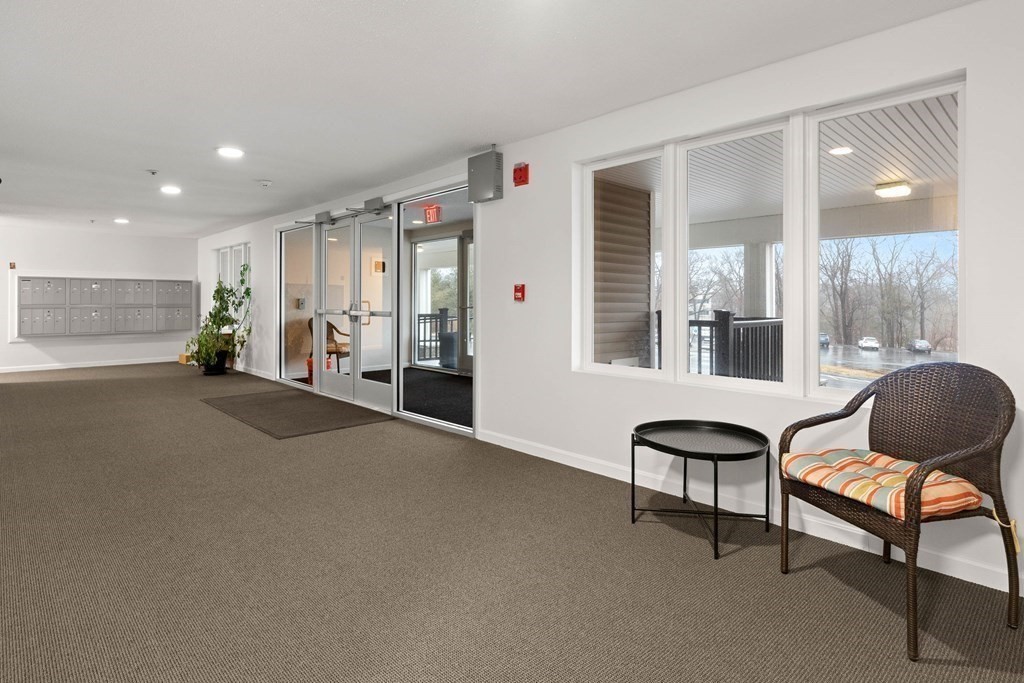 36 Dunham Road, Unit 306 Beverly, MA 01915 - Photo 24 of 26 a living room with furniture and a chair