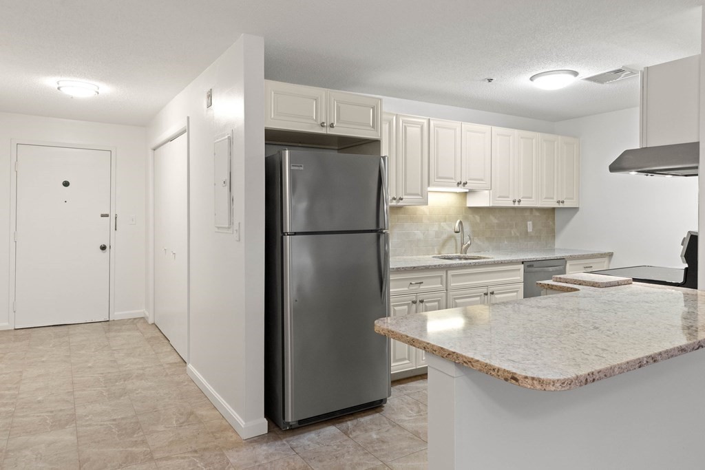 36 Dunham Road, Unit 306 Beverly, MA 01915 - Photo 3 of 26 a kitchen with stainless steel appliances granite countertop a refrigerator a sink and a stove
