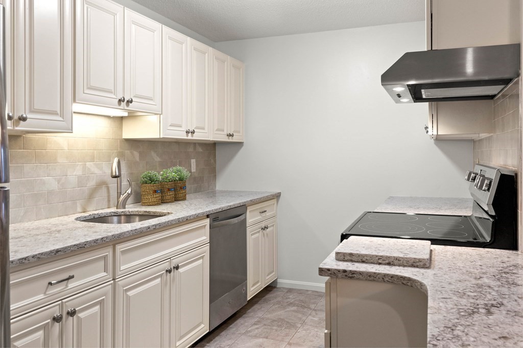 36 Dunham Road, Unit 306 Beverly, MA 01915 - Photo 6 of 26 a kitchen with granite countertop white cabinets and a stove