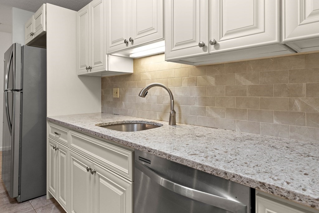 36 Dunham Road, Unit 306 Beverly, MA 01915 - Photo 7 of 26 a kitchen with stainless steel appliances granite countertop a sink dishwasher a refrigerator and cabinets with wooden floor