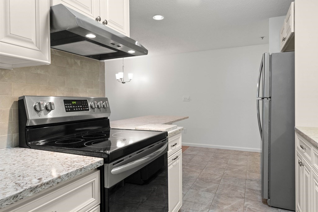 36 Dunham Road, Unit 306 Beverly, MA 01915 - Photo 8 of 26 a kitchen with stainless steel appliances granite countertop a refrigerator and a stove