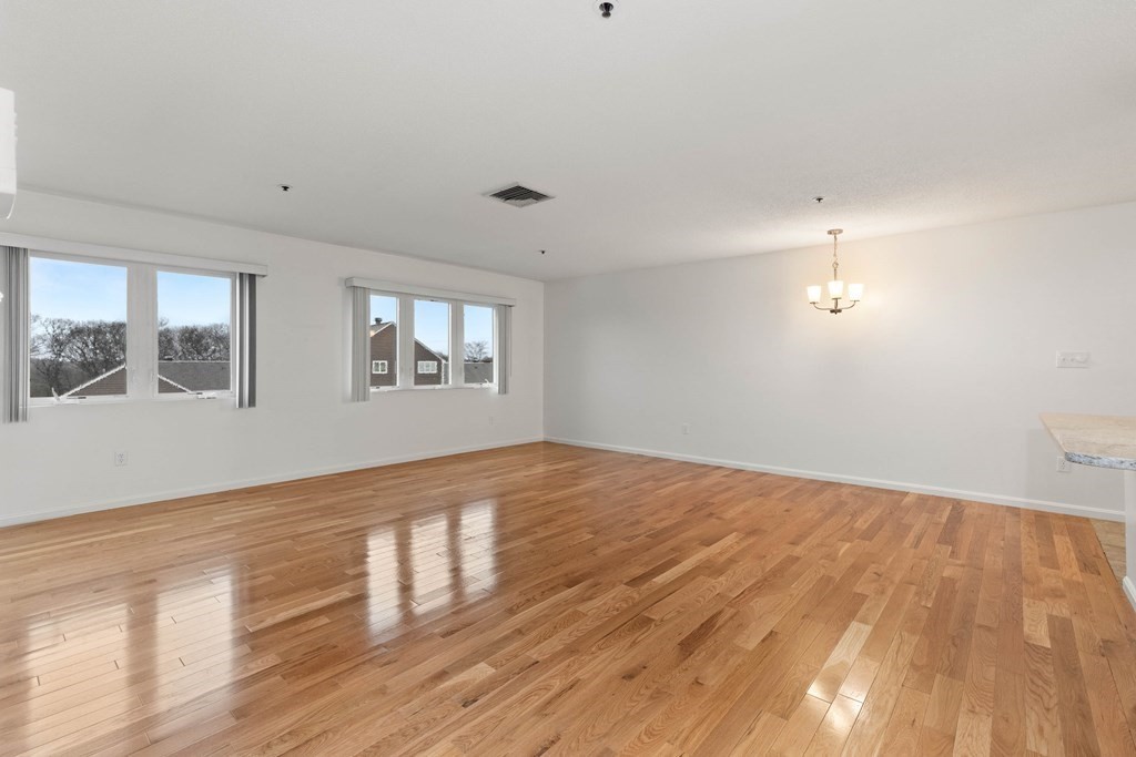 36 Dunham Road, Unit 306 Beverly, MA 01915 - Photo 10 of 26 an empty room with wooden floor and windows