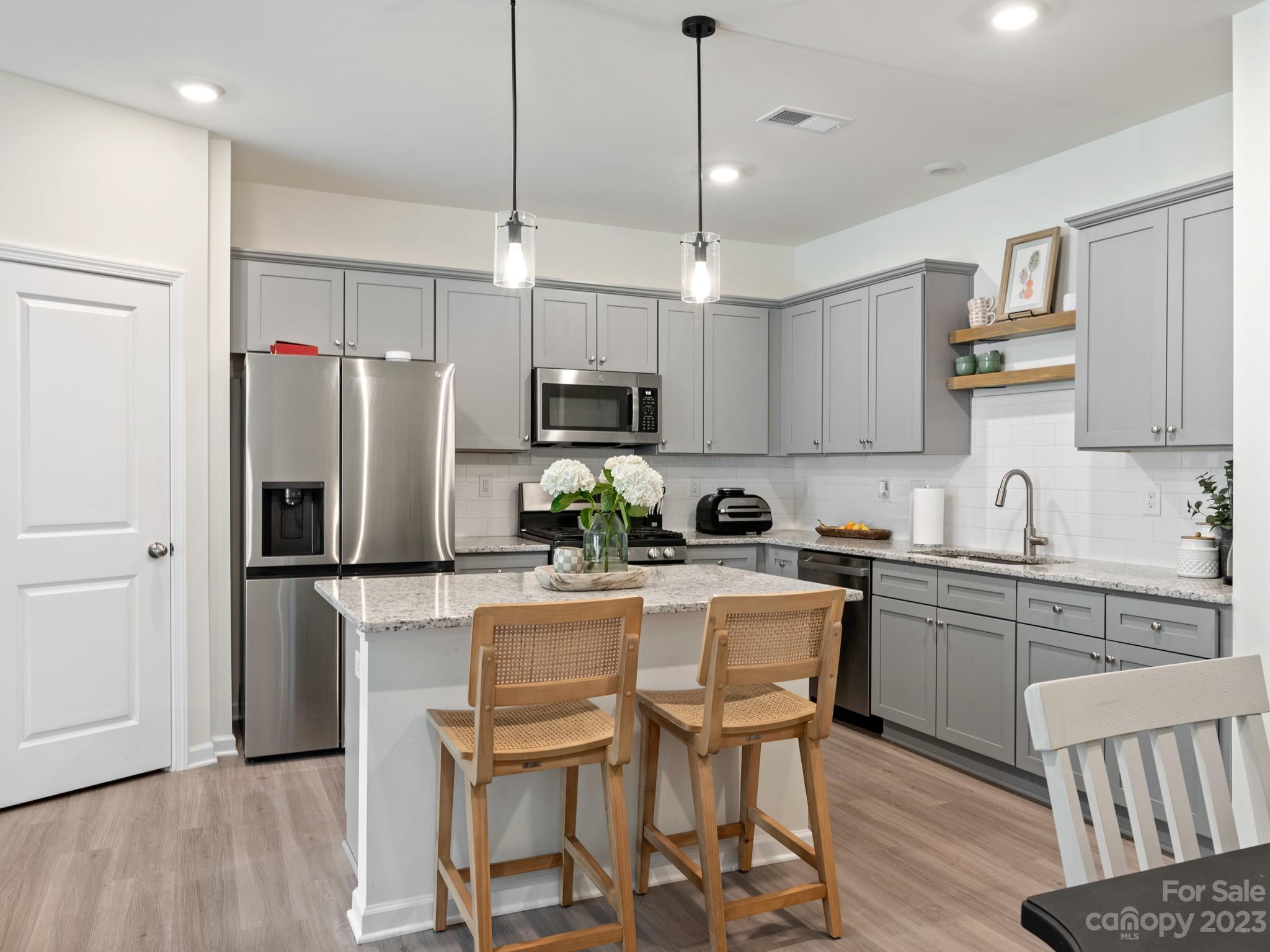 a kitchen with kitchen island white cabinets and stainless steel appliances