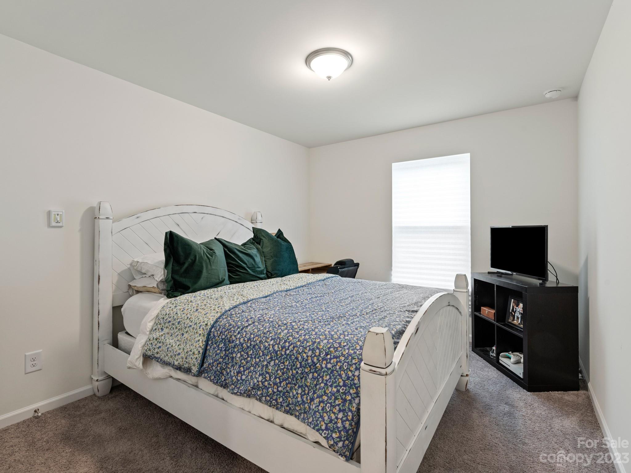 225 Quinn Road Matthews, NC 28104 - Photo 18 of 24 a bedroom with a bed and a television