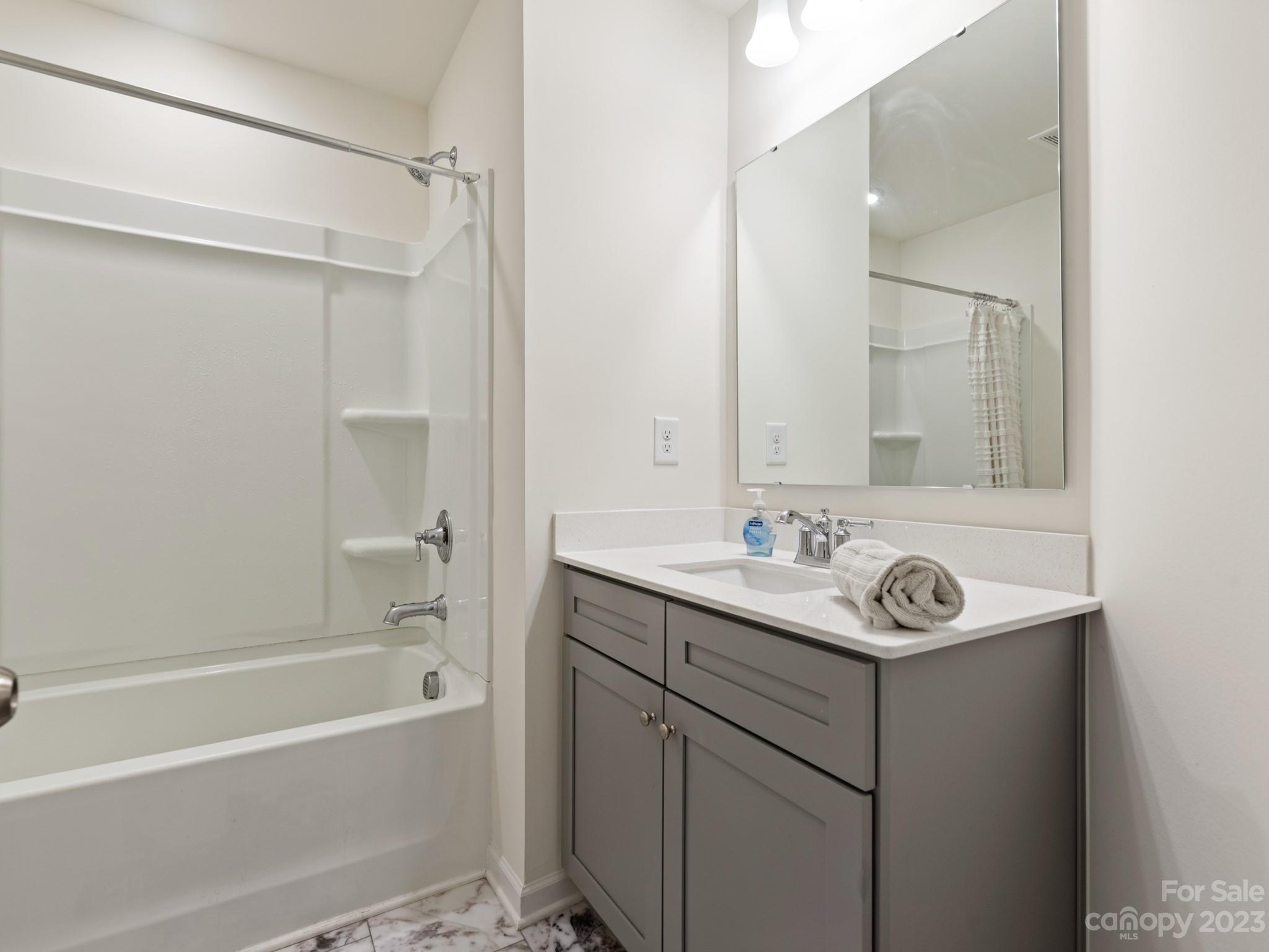 225 Quinn Road Matthews, NC 28104 - Photo 20 of 24 a bathroom with a sink a mirror and a bathtub