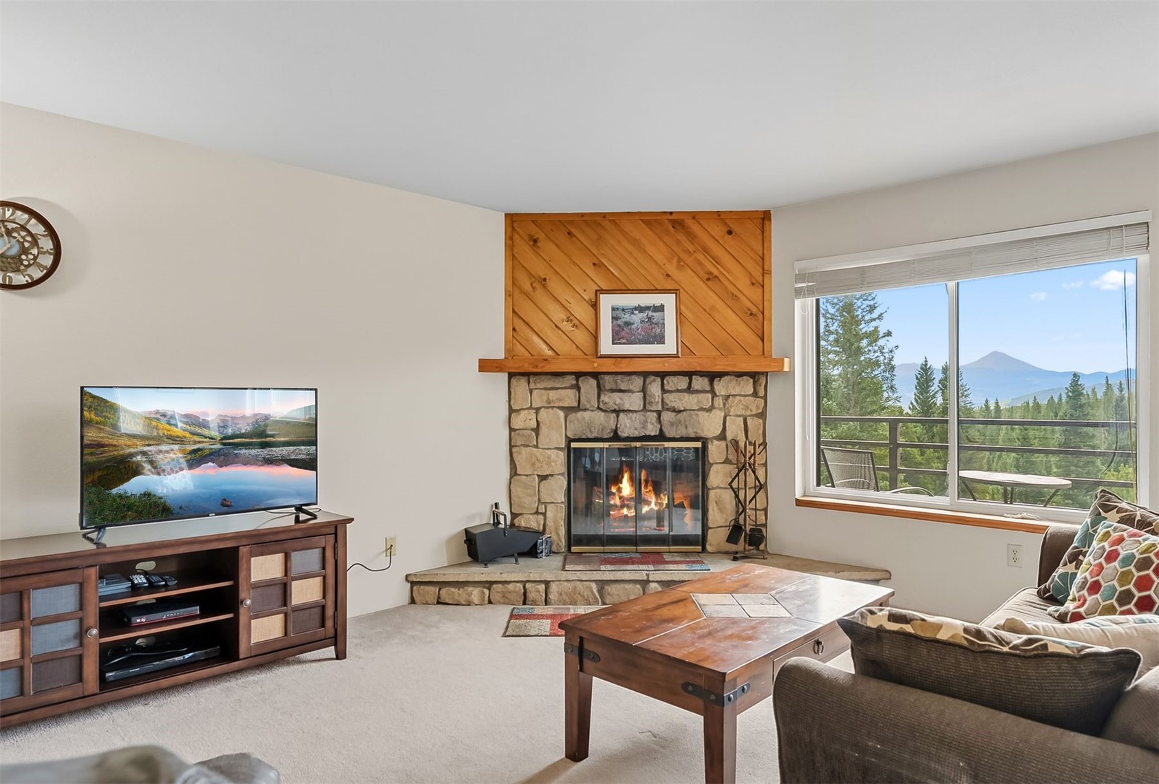 9849 Ryan Gulch Road, Unit 203 Silverthorne, CO 80498 - Photo 7 of 35 Living area with a mountain view, a fireplace, and carpet