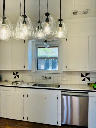 a kitchen with stainless steel appliances granite countertop a sink a counter space cabinets and wooden floor