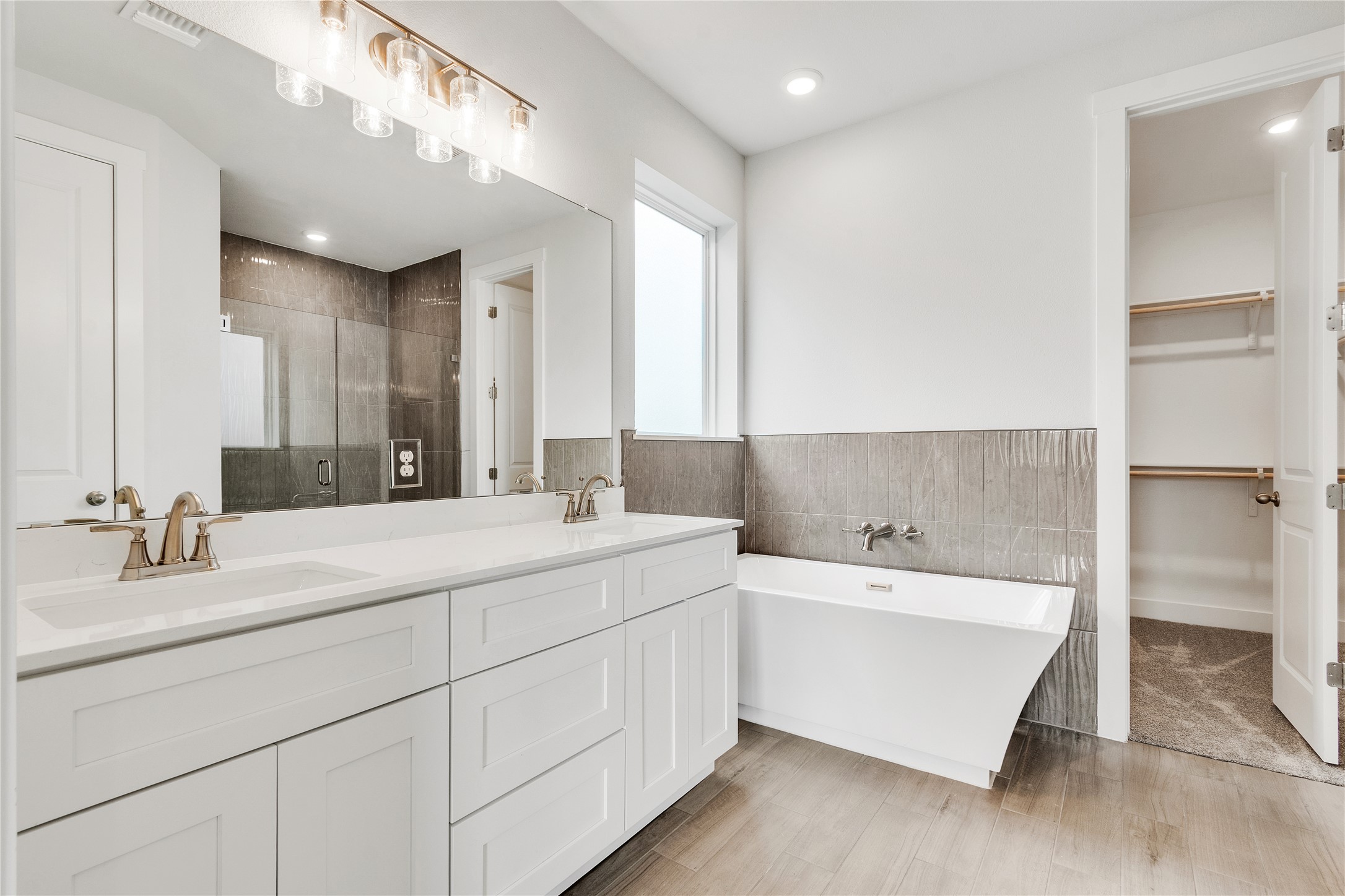 8500 Red Bottle Brush Road Lago Vista, TX 78645 - Photo 13 of 33 A well-appointed bathroom features a double vanity, separate tub, and walk-in shower.