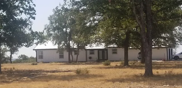 a white house that has a tree in front of it