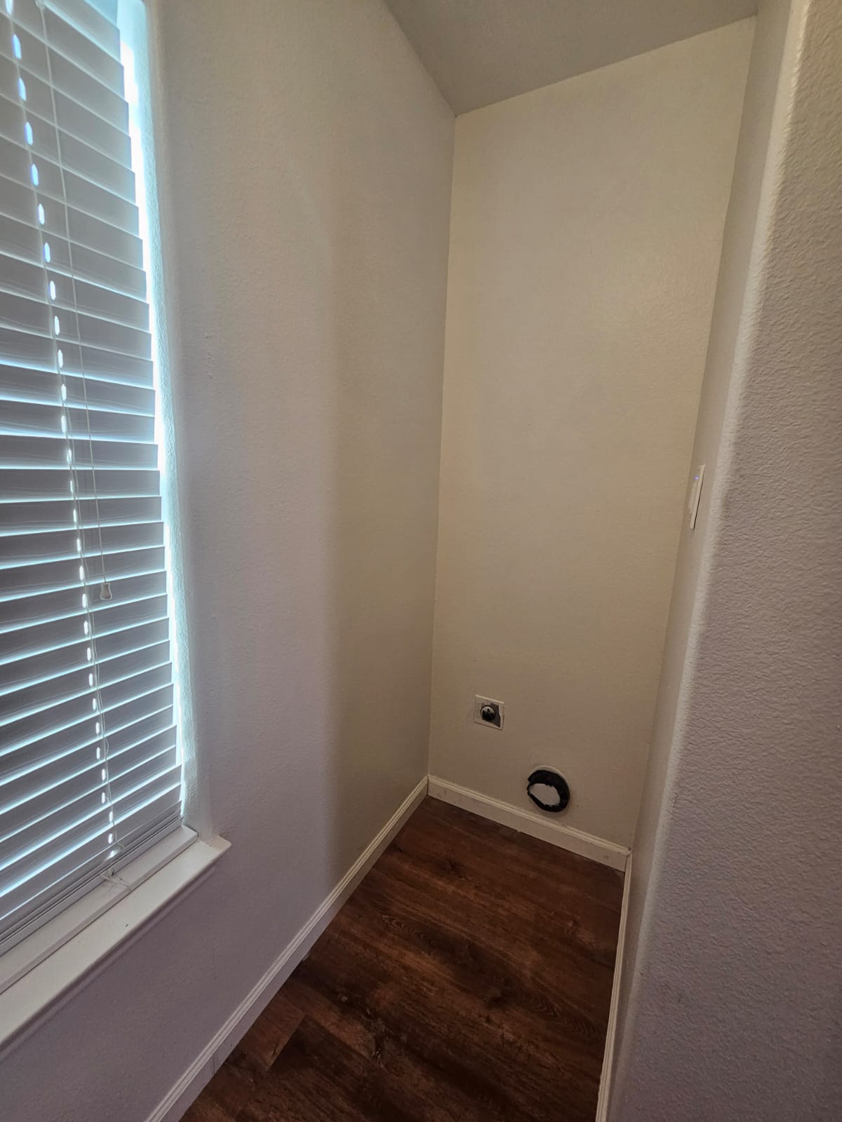 606 Trinity Street Lockhart, TX 78644 - Photo 17 of 23 A dedicated utility space with rich wood-look flooring awaits your laundry appliances.