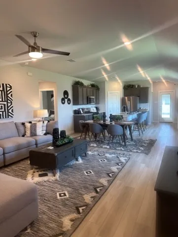 a living room with lots of furniture and view of kitchen
