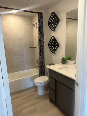 a bathroom with a sink a toilet a mirror and shower