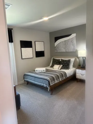 a bedroom with a bed and a painting on the wall