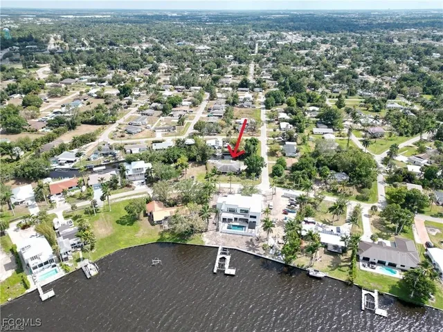 an aerial view of a house with a yard and lake view