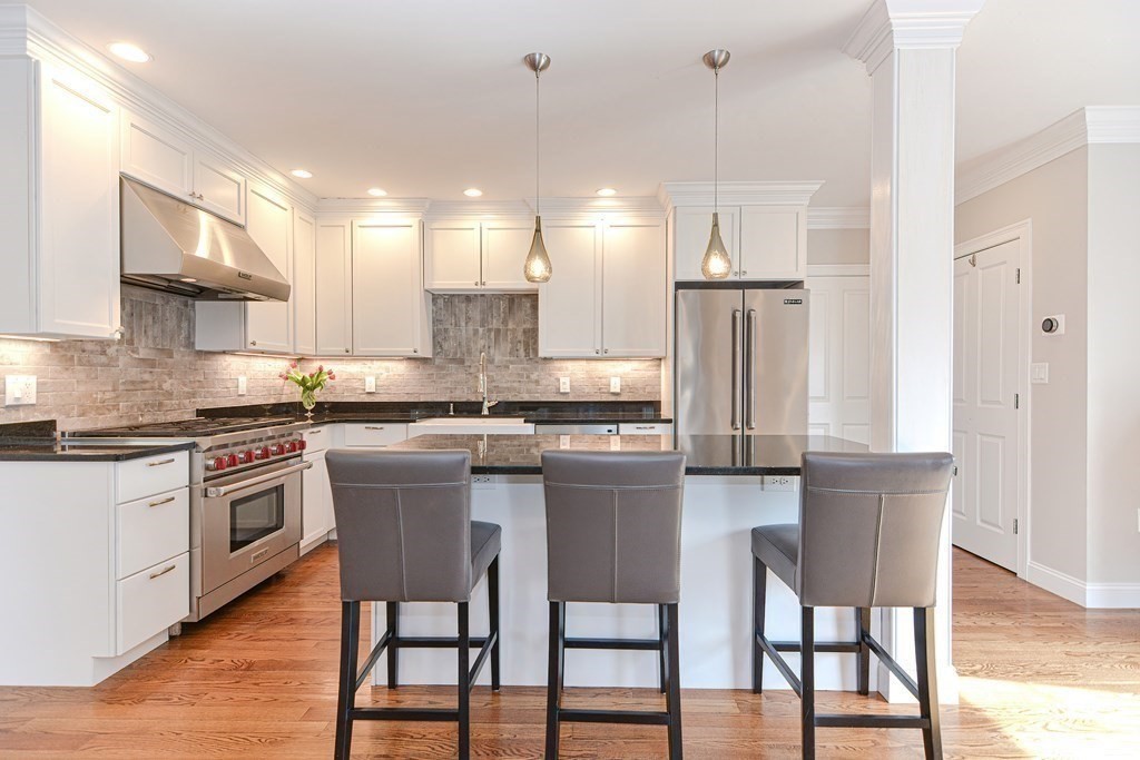 89 Walker Street, Unit 89 Newton, MA 02460 - Photo 12 of 42 a kitchen with stainless steel appliances granite countertop a kitchen island a table and chairs