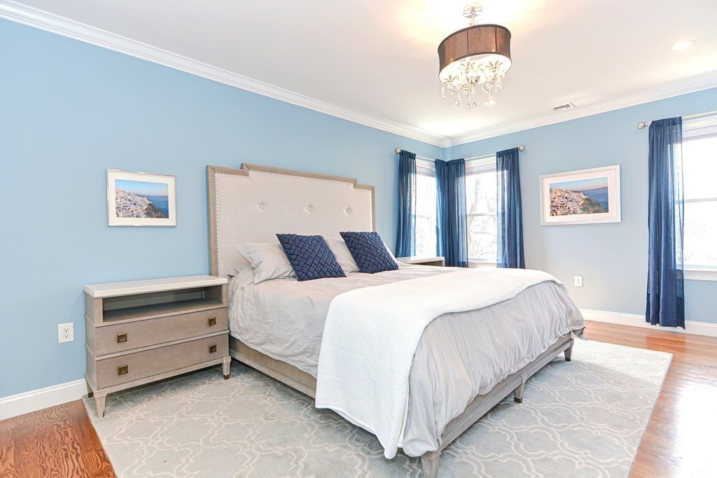 89 Walker Street, Unit 89 Newton, MA 02460 - Photo 19 of 42 a bedroom with a bed and a chandelier
