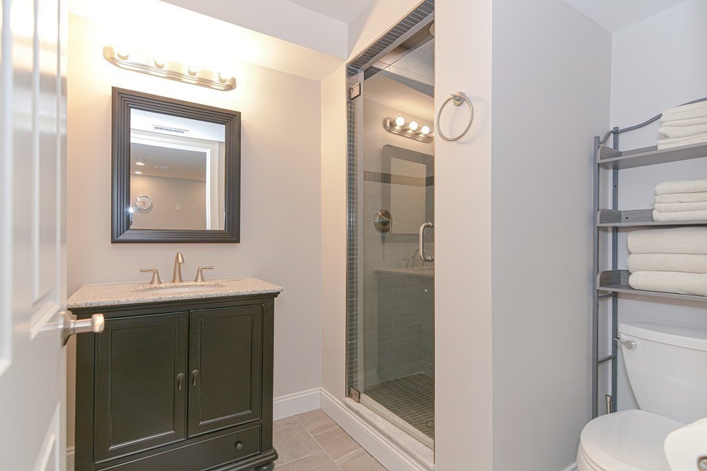89 Walker Street, Unit 89 Newton, MA 02460 - Photo 33 of 42 a bathroom with a toilet sink vanity and mirror