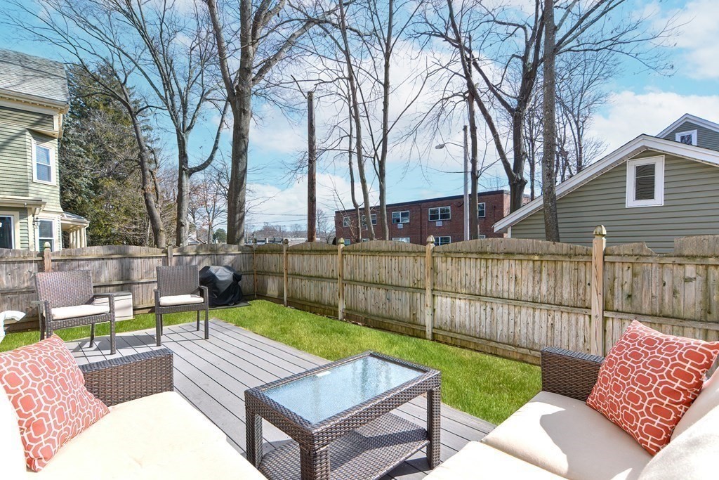 89 Walker Street, Unit 89 Newton, MA 02460 - Photo 37 of 42 a view of a backyard with couches potted plants and wooden fence