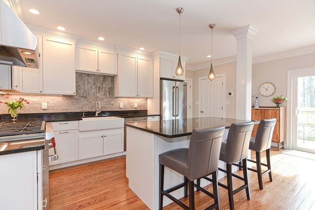 89 Walker Street, Unit 89 Newton, MA 02460 - Photo 10 of 42 a kitchen with stainless steel appliances kitchen island granite countertop a dining table chairs and sink