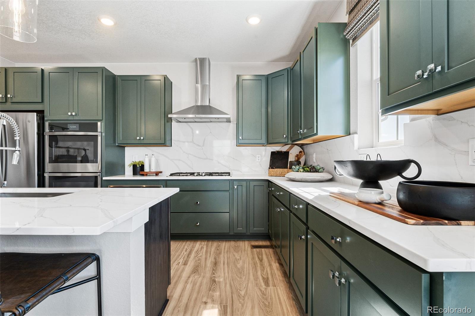 4261 Ridgewalk Point Castle Rock, CO 80108 - Photo 28 of 39 a kitchen with a sink dishwasher a stove and a refrigerator with wooden floor