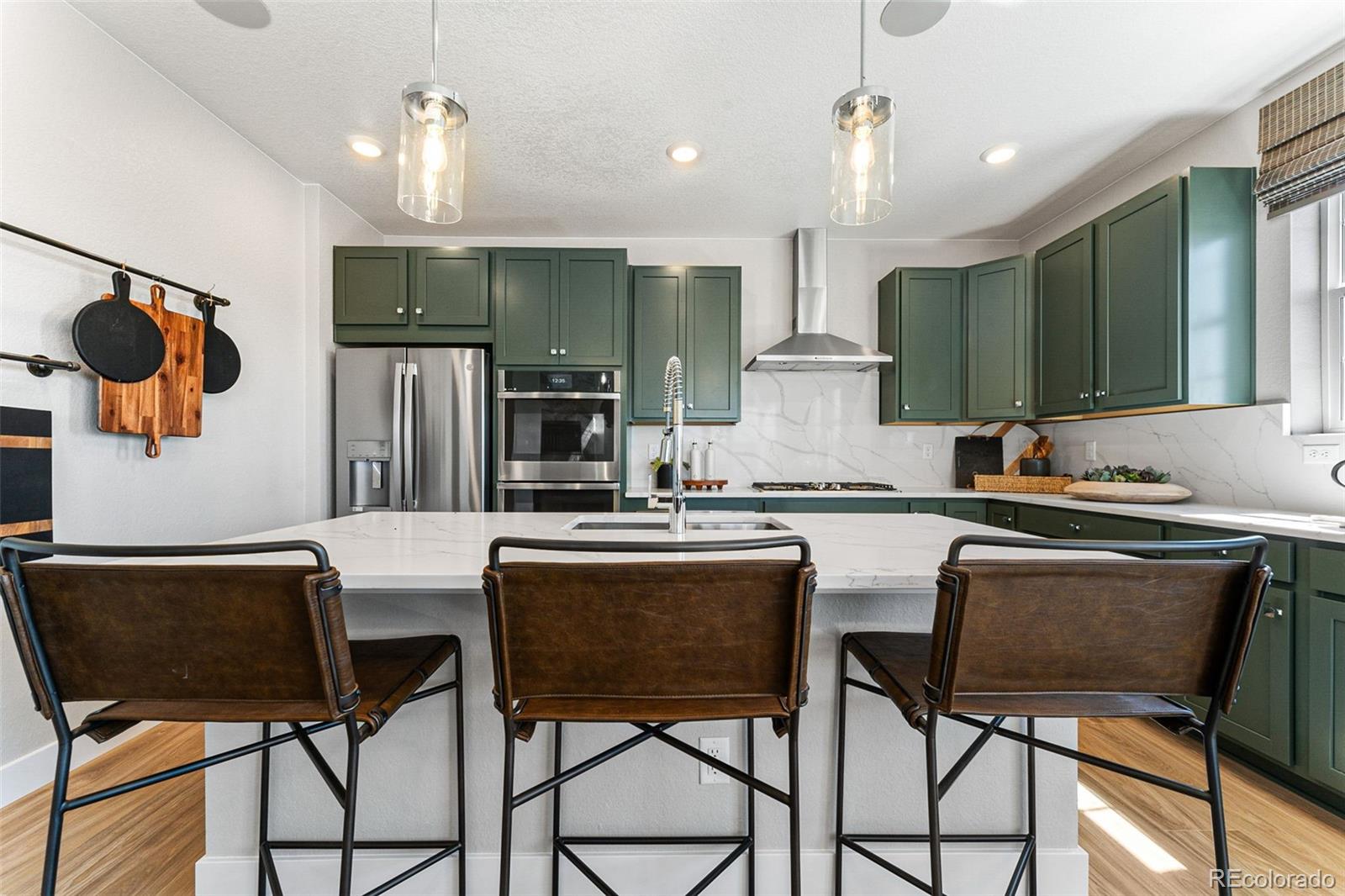 4261 Ridgewalk Point Castle Rock, CO 80108 - Photo 29 of 39 a kitchen with stainless steel appliances granite countertop a sink a stove a refrigerator cabinets and chairs