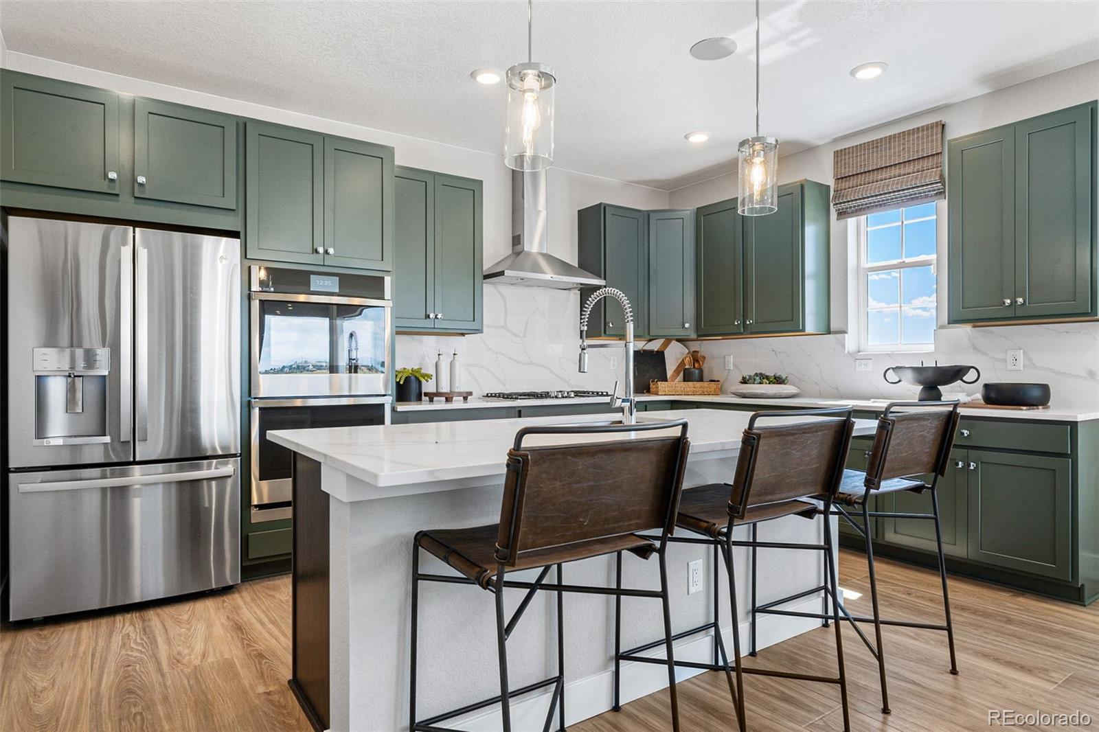 4261 Ridgewalk Point Castle Rock, CO 80108 - Photo 30 of 39 a kitchen with stainless steel appliances granite countertop a sink a stove a refrigerator cabinets and wooden floor