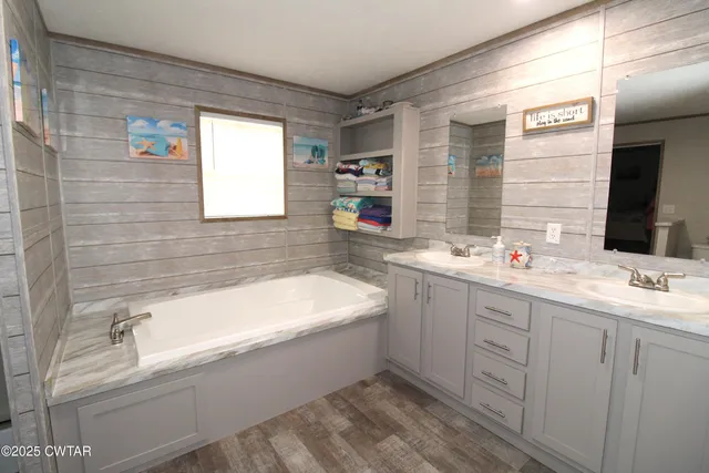 a bathroom with a bathtub sink and mirror