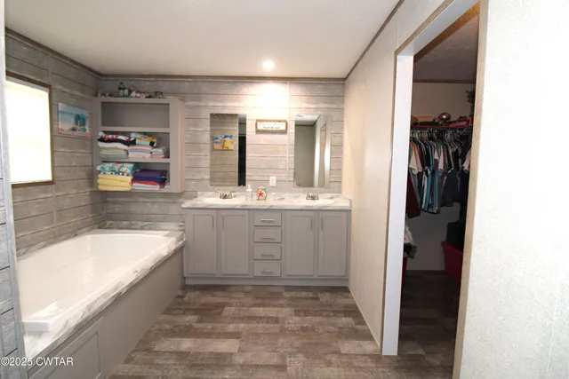 a bathroom with a tub sink and mirror