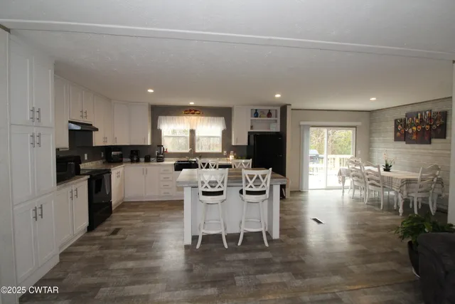 a kitchen with a dining table chairs stainless steel appliances and cabinets