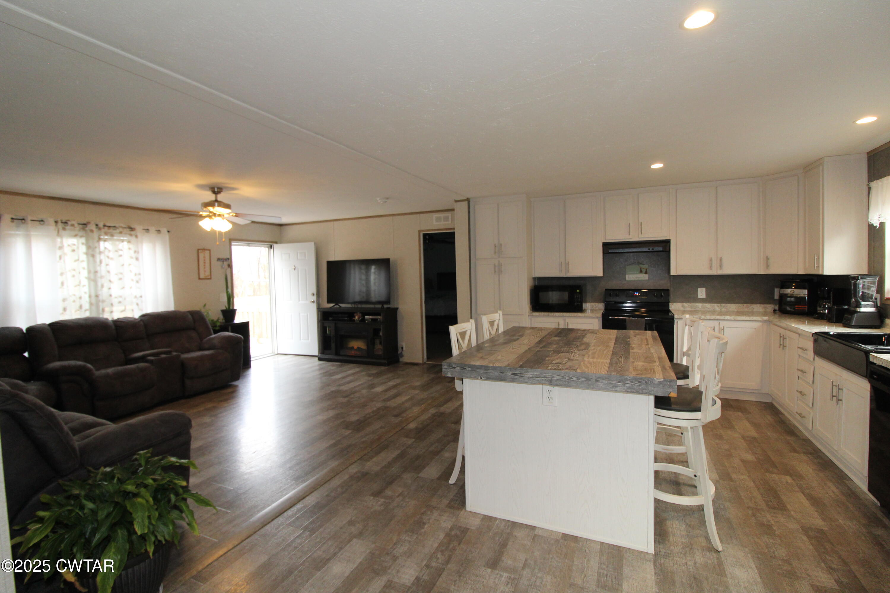 34 Rubin White Road Bradford, TN 38316 - Photo 6 of 35 a kitchen with a refrigerator a stove a sink dishwasher with a dining table and chairs with wooden floor