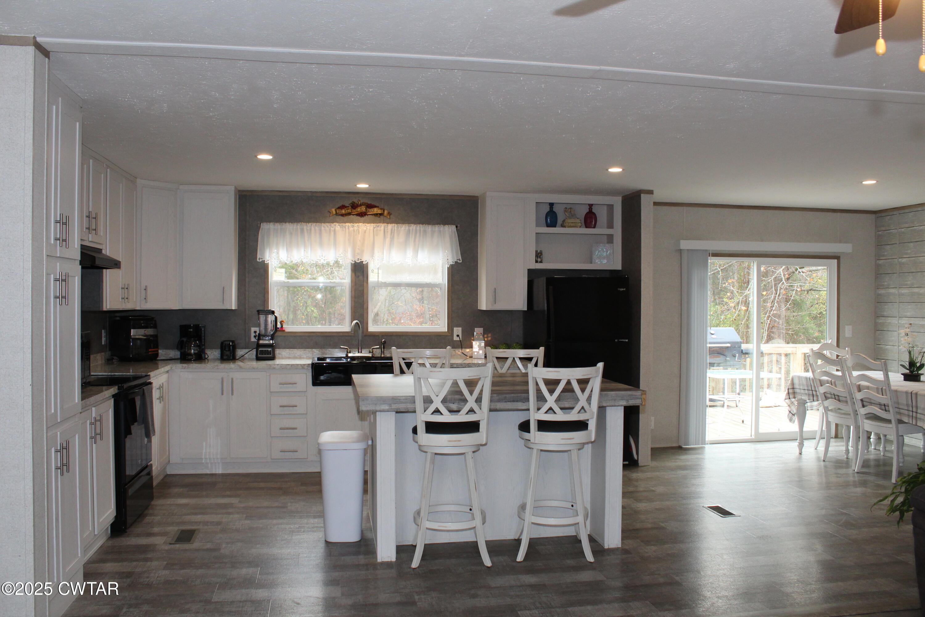 34 Rubin White Road Bradford, TN 38316 - Photo 7 of 35 a kitchen with stainless steel appliances granite countertop a stove top oven a sink dishwasher a dining table and chairs with wooden floor
