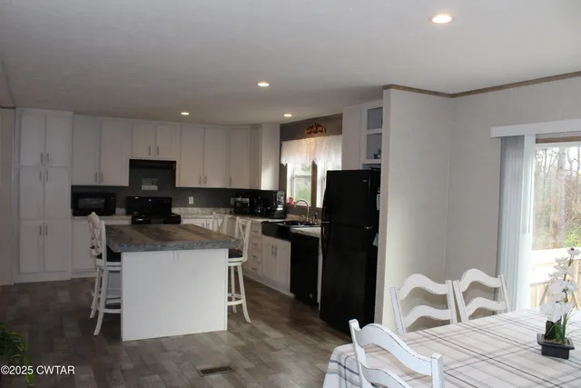a kitchen with a refrigerator and a stove top oven