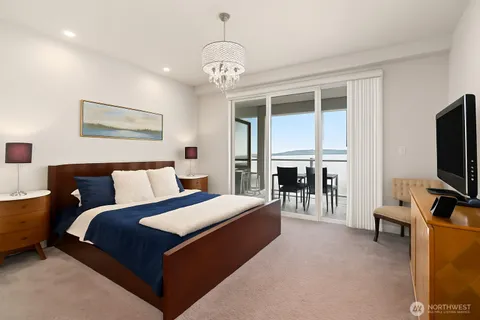 a spacious bedroom with a bed and a flat screen tv