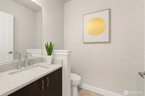 a bathroom with a toilet sink vanity and mirror