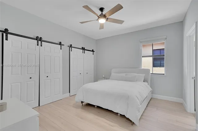 a bedroom with a bed and a ceiling fan