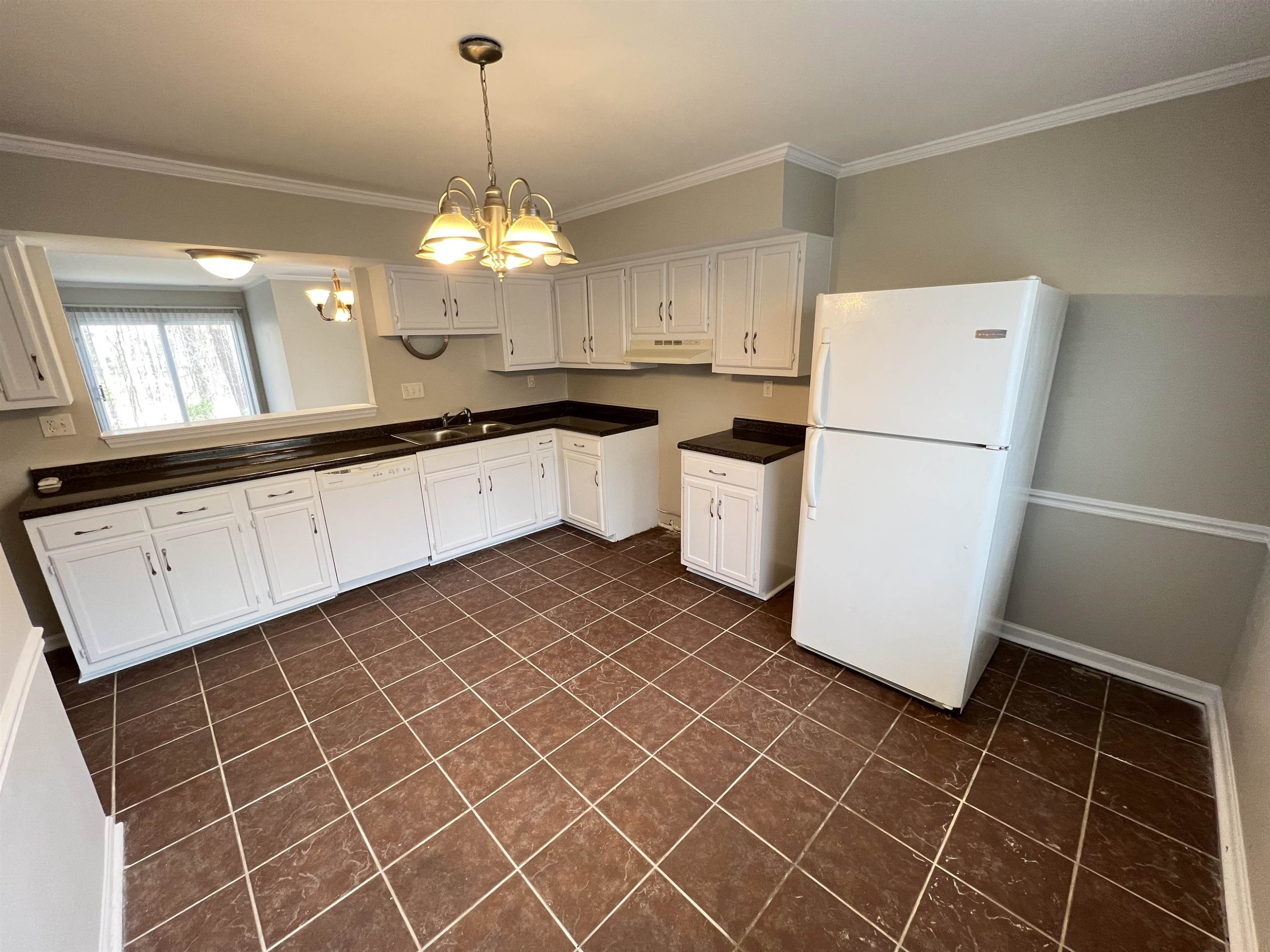 1227 Seaton Road, Unit 33 Durham, NC 27713 - Photo 19 of 21 a kitchen with a sink a refrigerator and a chandelier