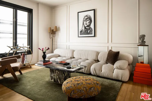 a living room with furniture and floor to ceiling window