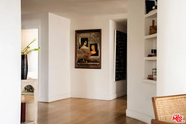 a view of a hallway with wooden floor and closet