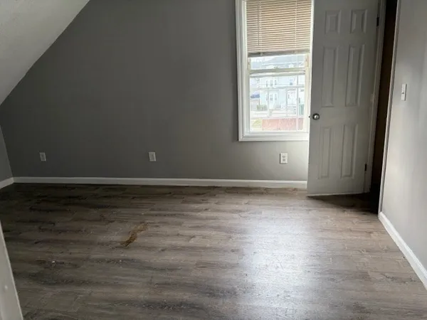 a view of a hallway with wooden floor and windows