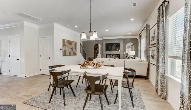 a view of a a dining room with furniture window and wooden floor