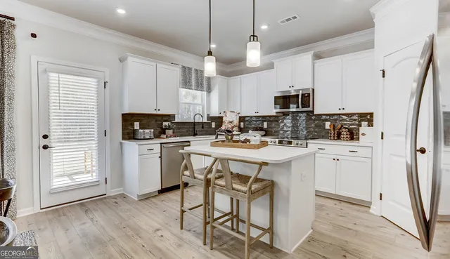 a kitchen with white cabinets and stainless steel appliances
