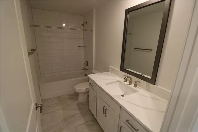 an empty room with wooden floor and sink