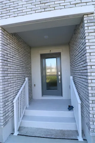 a view of a hallway with wooden floor and entryway
