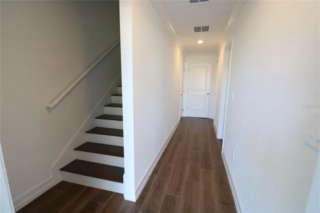 a view of a hallway with wooden floor