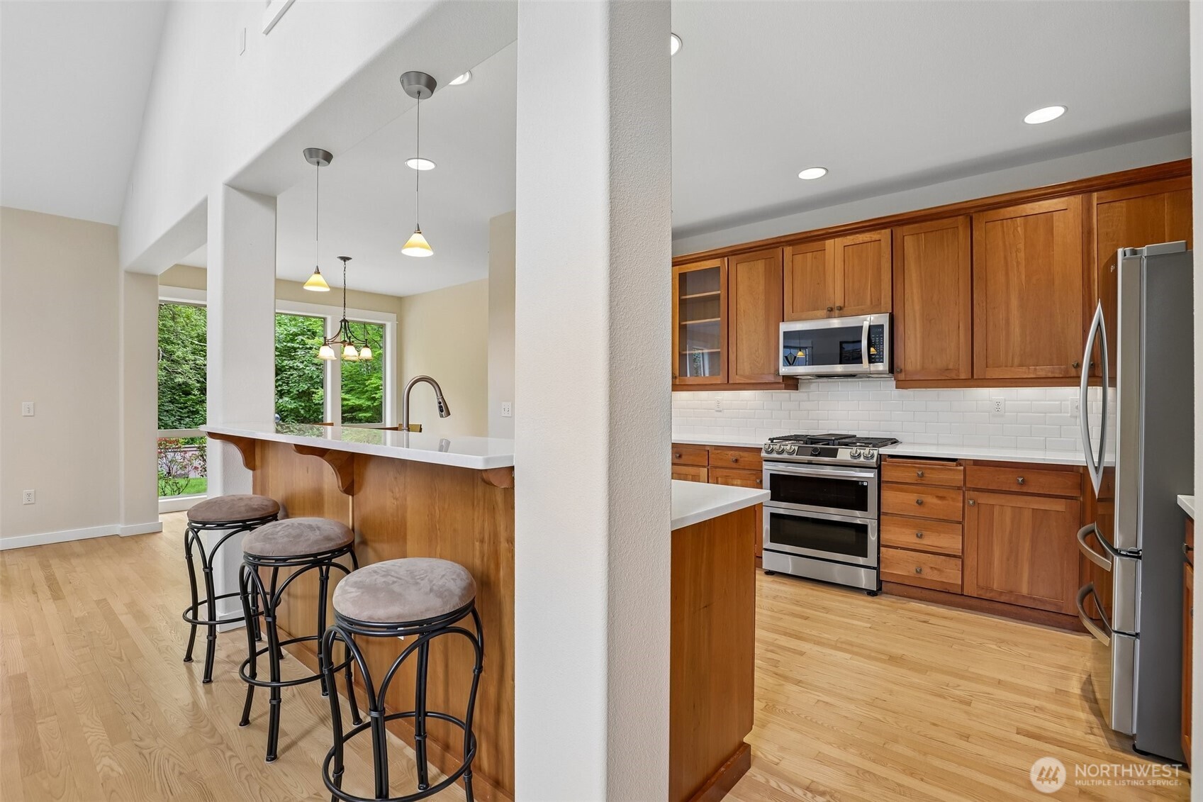 19709 Southeast 26th Way Camas, WA 98607 - Photo 10 of 36 a kitchen with stainless steel appliances kitchen island granite countertop a refrigerator a stove top oven and a sink with wooden floor