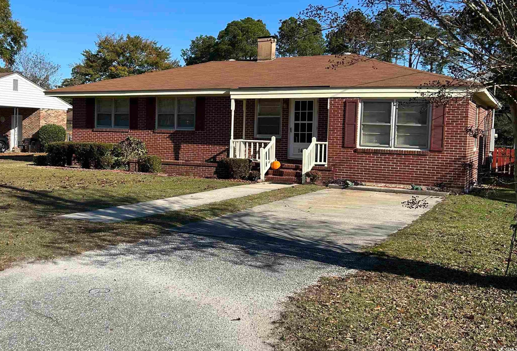 1411 East Harrison Street Dillon, SC 29536 - Photo 2 of 40 Ranch-style house with a front yard, brick siding, a chimney, and driveway